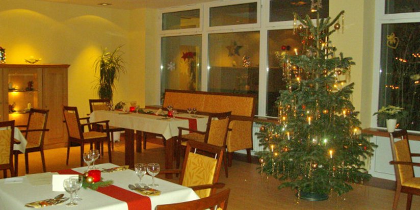 Leuchtender Weihnachtsbaum in festlich geschmückter Cafeteria 