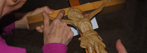 Bewohnerin hält Jesus am Kreuz in ihrer Hand 