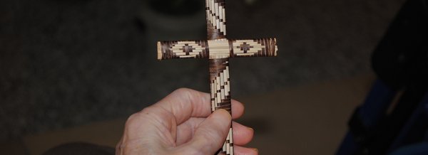 Eine Bewohnerin hält ein kleines Kreuz in der Hand 